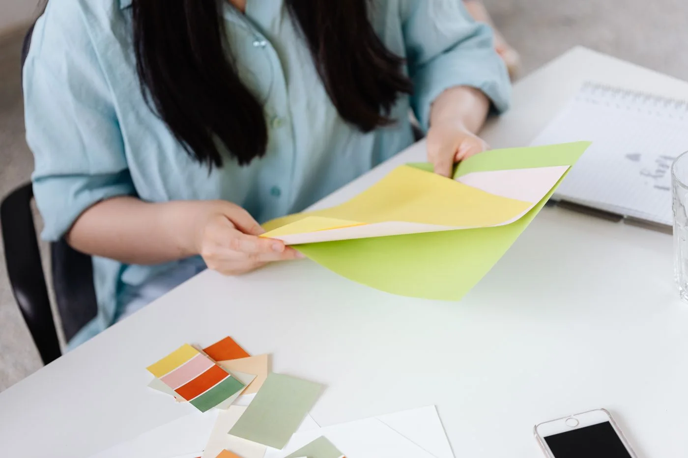 Gestalterin vergleicht Farbmuster aus Papier