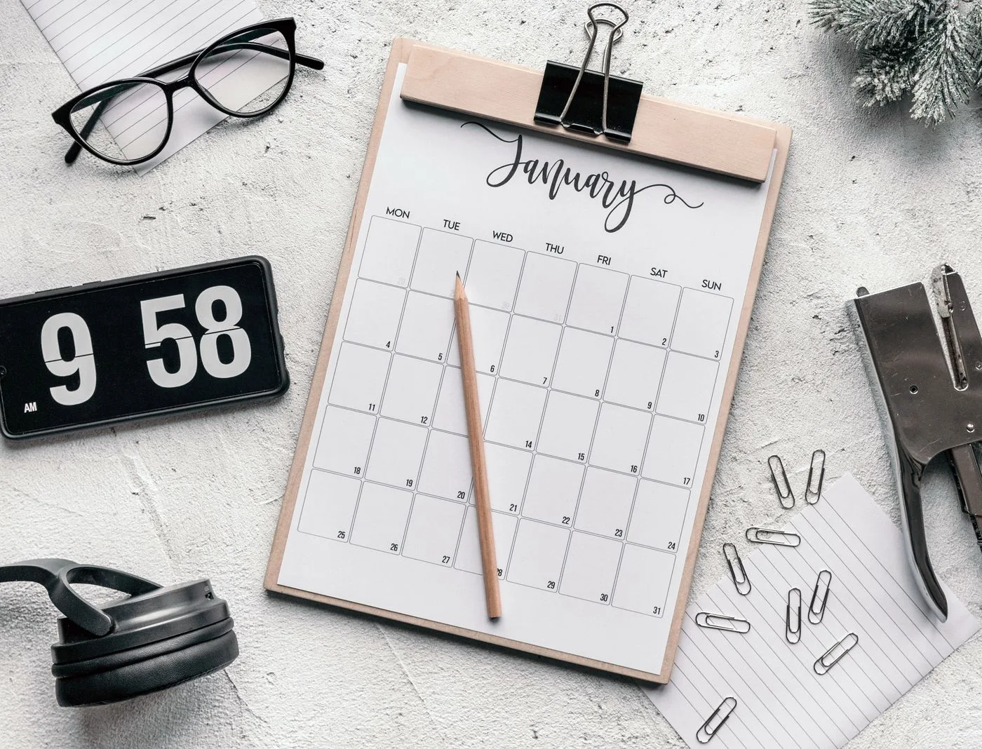Kalender auf einem Klemmbrett mit Schreibmaterial