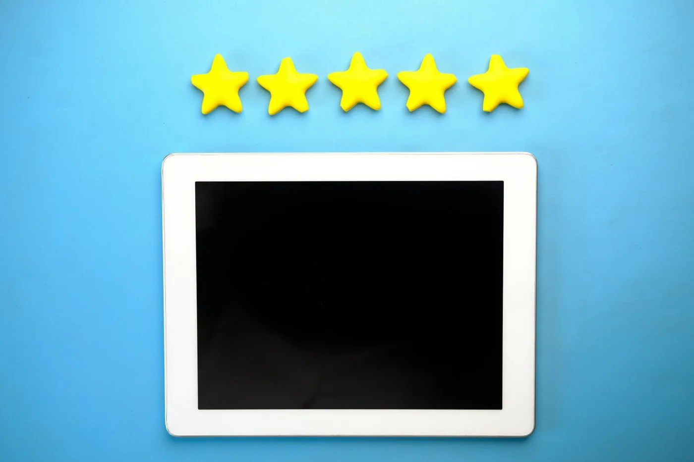 Fünf Bewertungssterne über einem Tablet