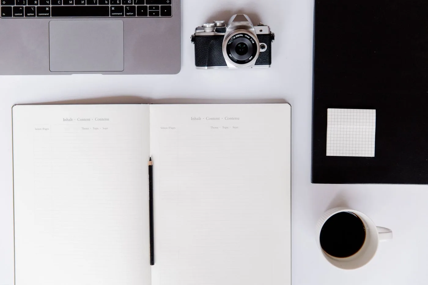 Arbeitsplatz mit Kamera und Notizbuch
